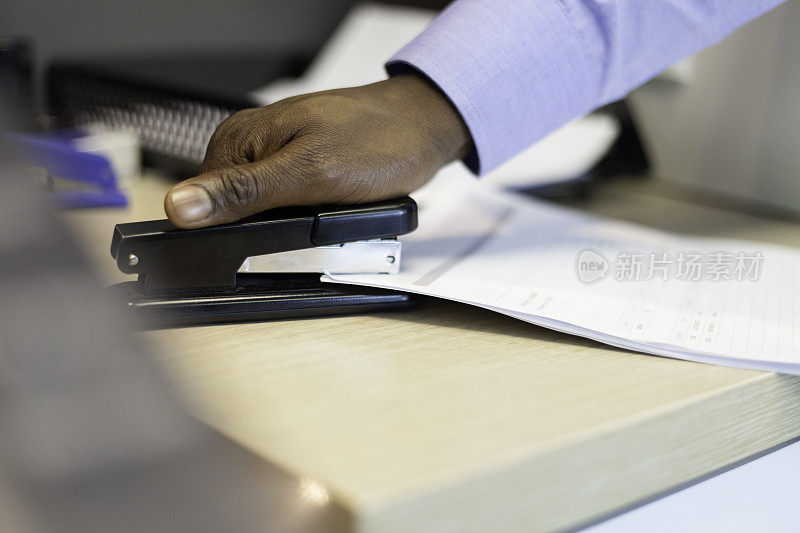 非洲商人用订书机装订文件。