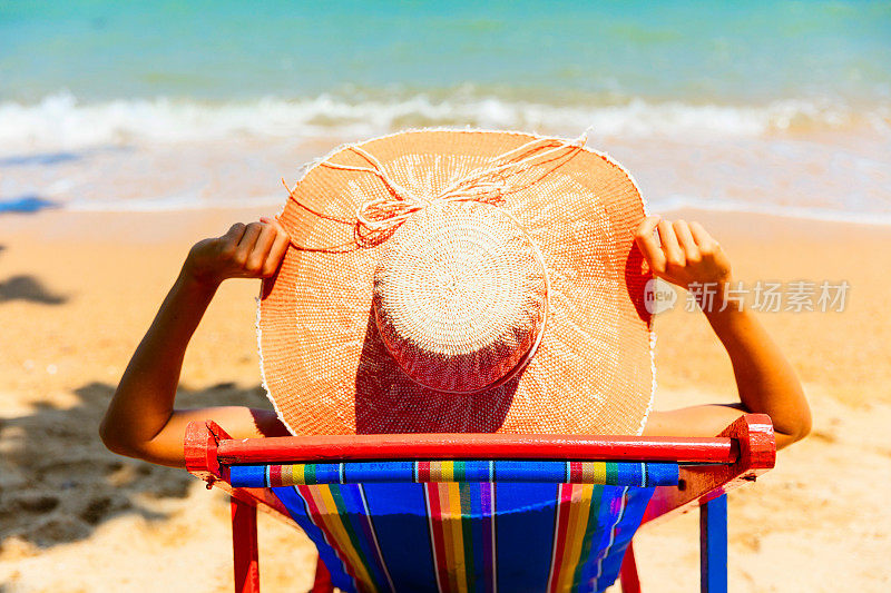 坐在沙滩椅上晒太阳的女人