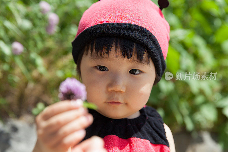 穿着瓢虫服装的小女孩找到了花