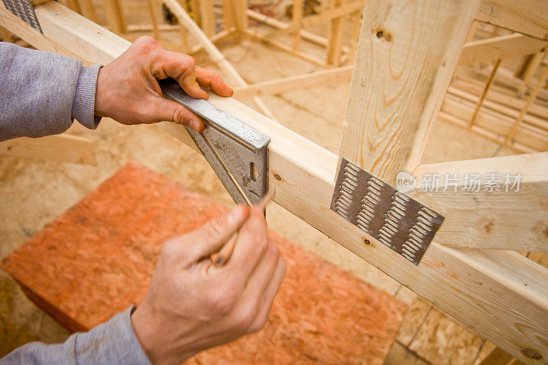 建筑工人使用速度尺和标记桁架板