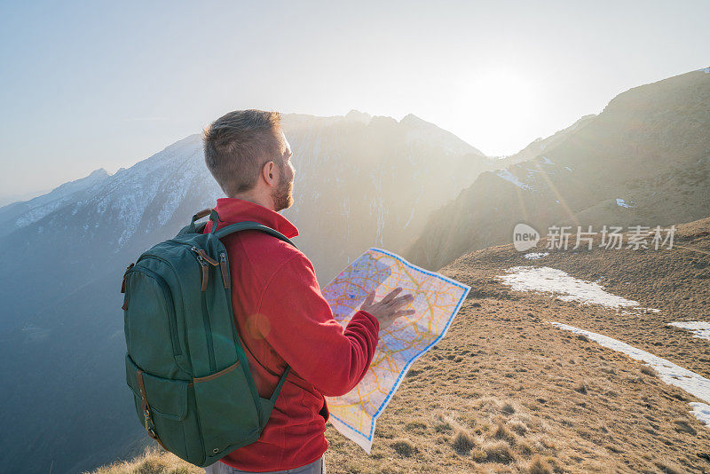 一个年轻人在瑞士徒步旅行，一边看地图
