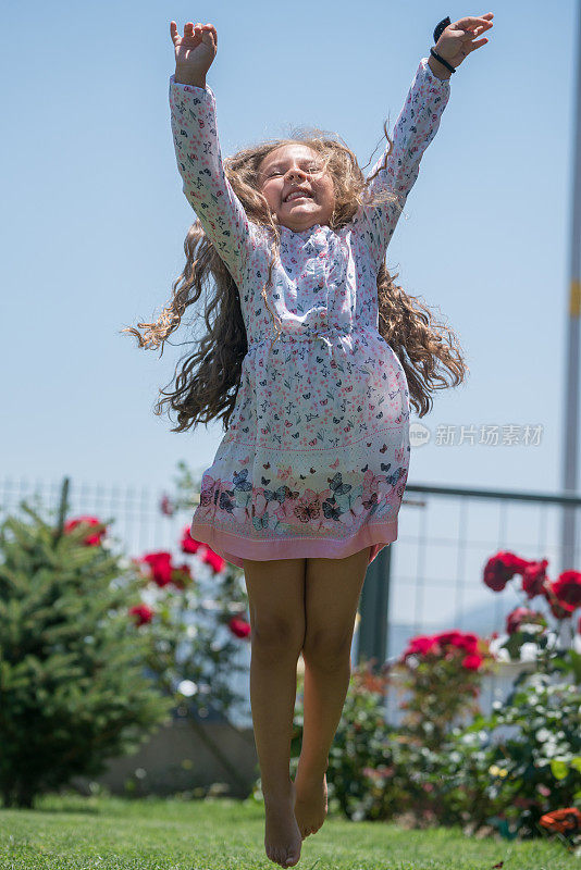 在家庭花园里蹦蹦跳跳的女孩