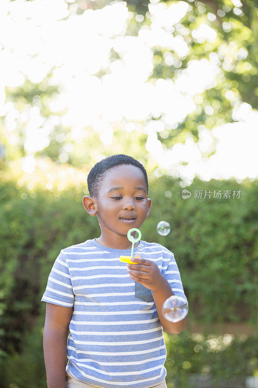 男孩用泡泡棒吹泡泡的肖像