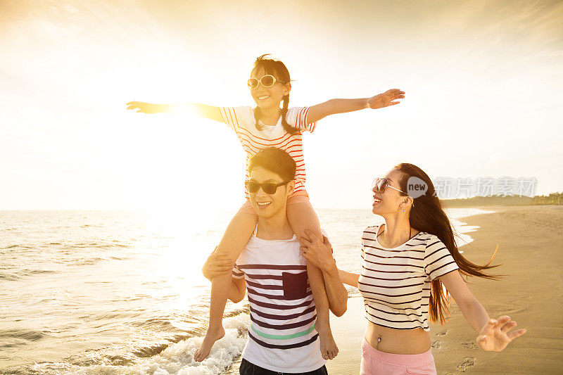 日落时分，幸福的一家人在海滩上玩耍