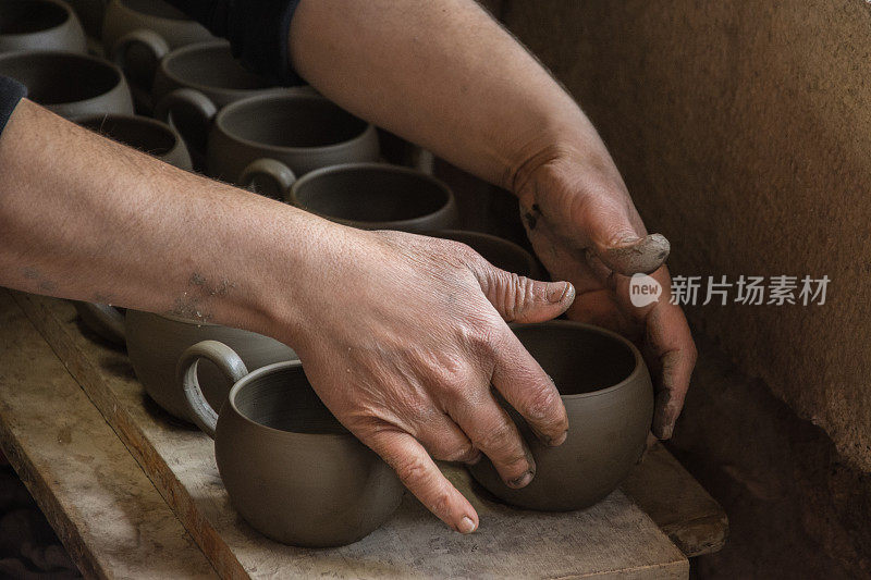 在克里特岛Rethimno，妇女陶工在创造一些传统的白色粘土杯。