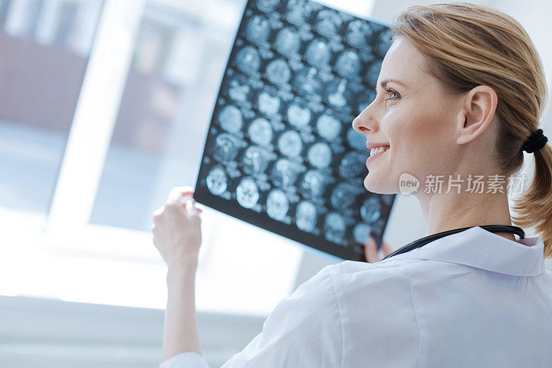 自信的神经外科医生在实验室分析x光片的脑部结果