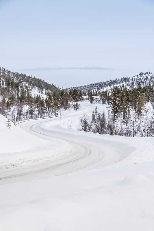 典型的芬兰景观和冰雪覆盖的冬季道路