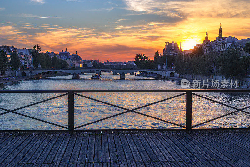 从艺术桥上俯瞰法国巴黎塞纳河上的戏剧性日落。