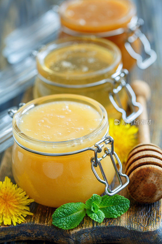 不同品种的蜂蜜在玻璃罐子里。