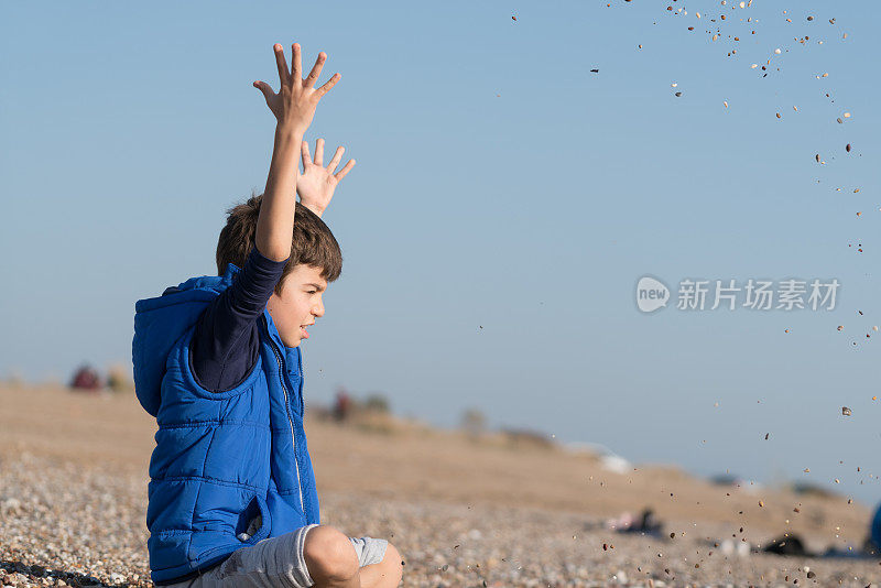 快乐的男孩在一个冬天的一天在沙滩上玩