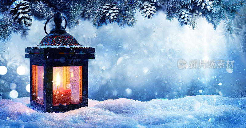 圣诞灯笼在雪与冷杉枝在晚上的景象