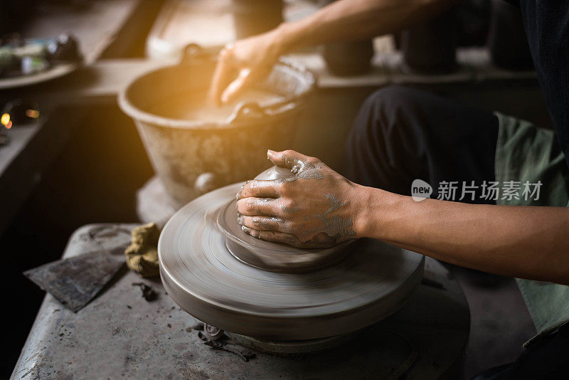 特写陶工的手塑造软粘土，使一个瓦锅
