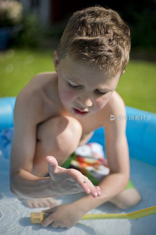 六岁男孩在嬉水池里