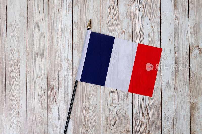 一面法国国旗放在木制的桌面上