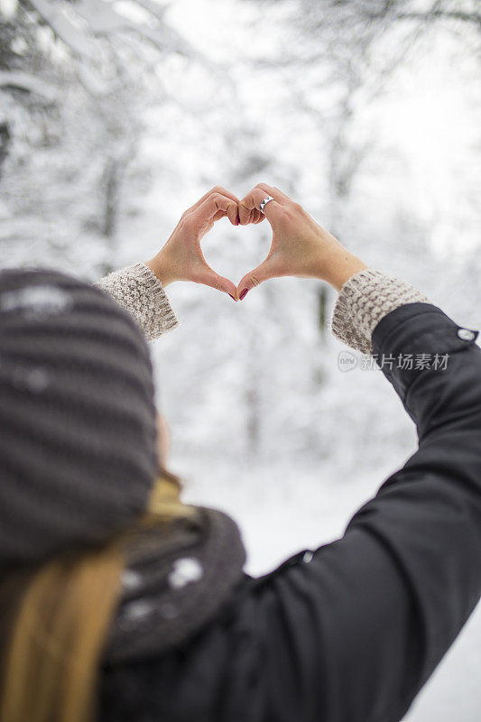 女人在冬天双手制作心形的象征