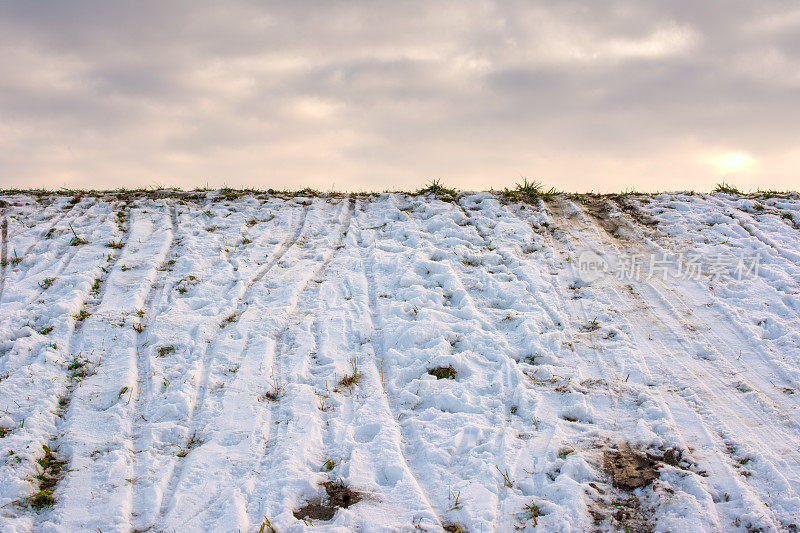 冬天雪中有雪橇痕迹的小山