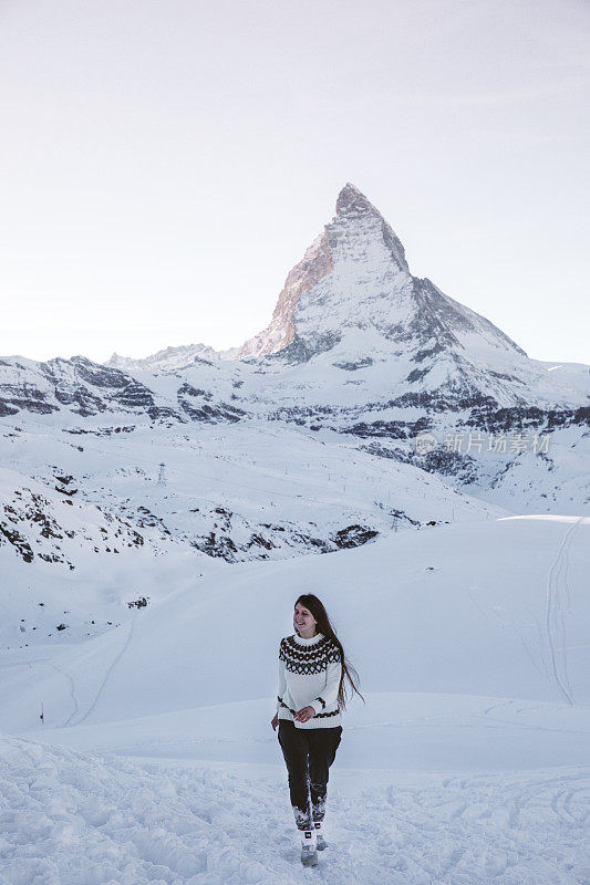 身着羊毛衫的女子在冬季瑞士阿尔卑斯山马特洪峰附近散步