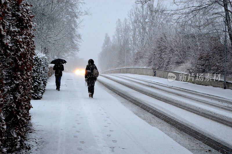 在暴风雪中打着伞的行人