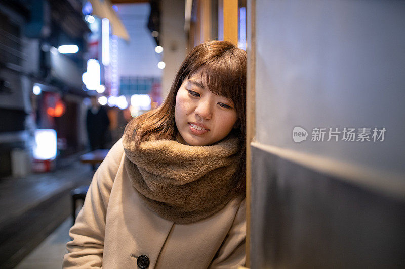 年轻女子放松在户外日本居酒屋餐厅下班后