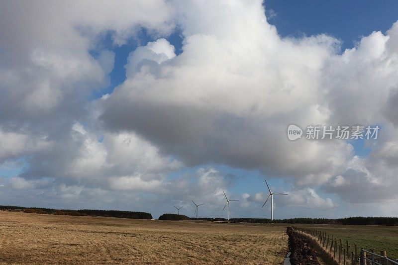 蓝天下的风力涡轮机和蓬松的白云