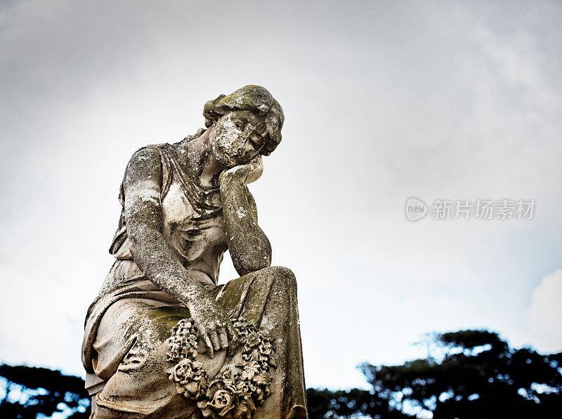 一个悲伤的年轻女子在一个1932年的墓地纪念碑上哀悼