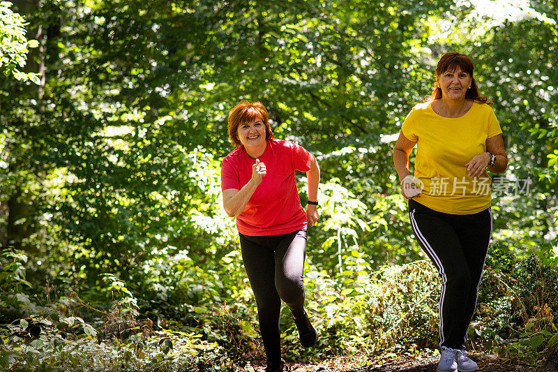 两个中年妇女跑过森林