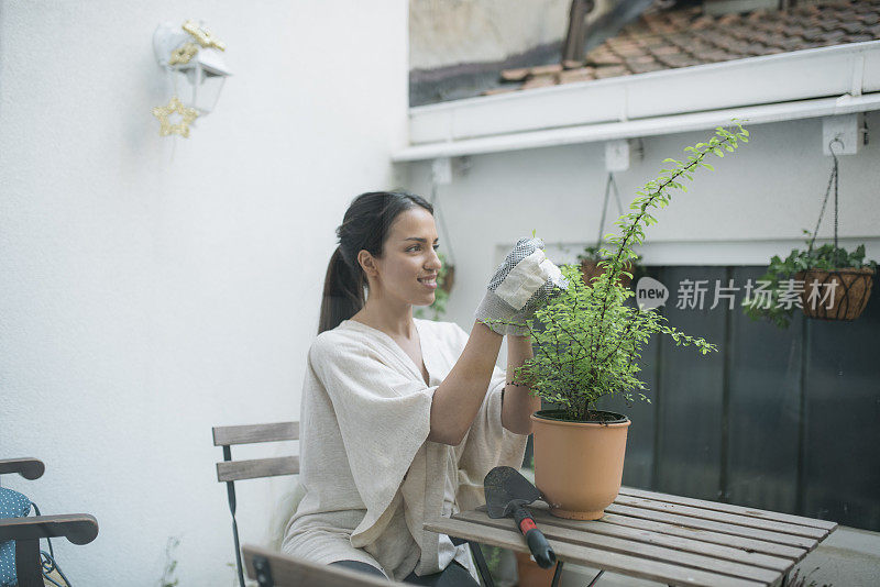 一位年轻女子在阳台上照料她的花园