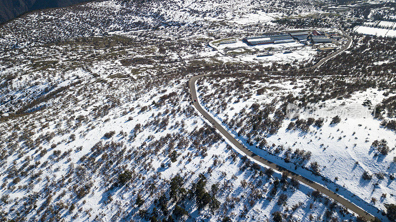 无人机拍摄的美丽雪山冬季弯弯曲曲的道路