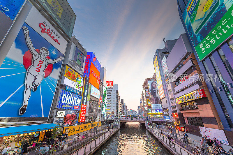 在日本大阪的道顿堀，五颜六色的广告牌照亮了大阪夜市周围的商店和零售店