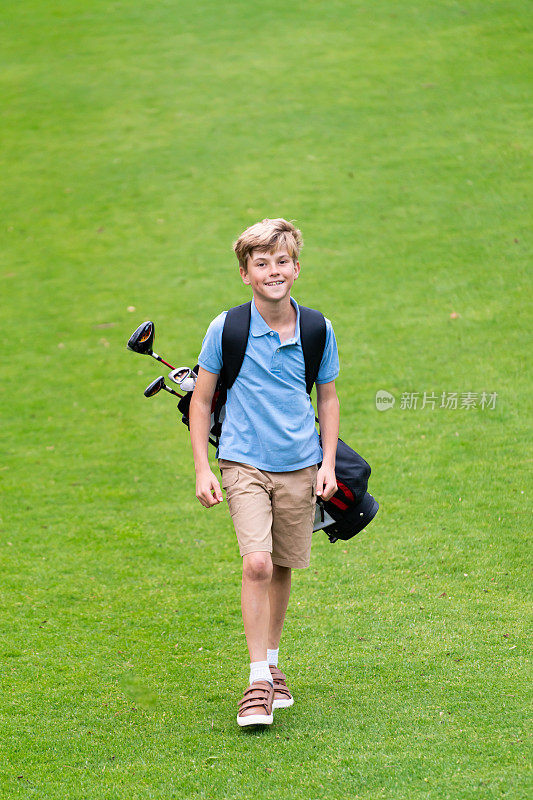 9岁男孩在高尔夫球场上散步