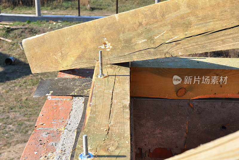 屋面施工。在屋角安装木椽子，框架木材和沥青防水材料。