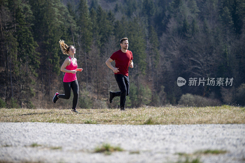 一对年轻夫妇在一个阳光明媚的日子里跑步