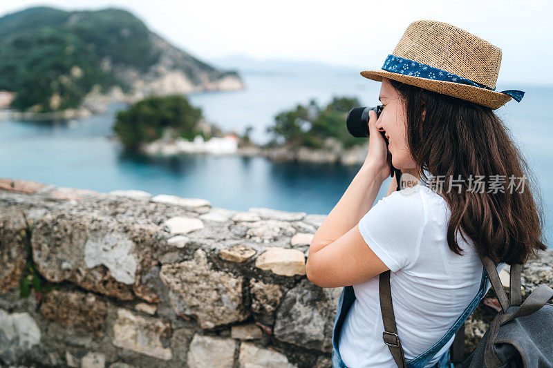 在海边拍摄照片的女人