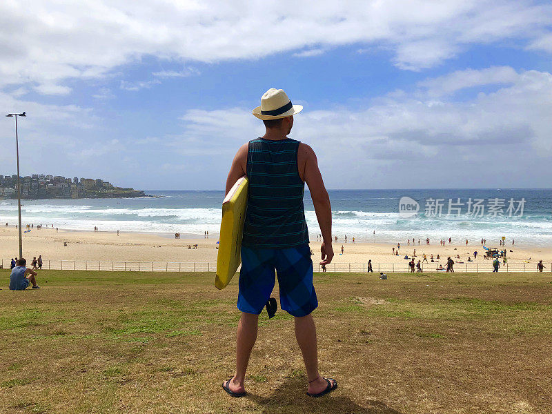 拉丁男游客准备在澳大利亚悉尼的邦迪海滩冲浪