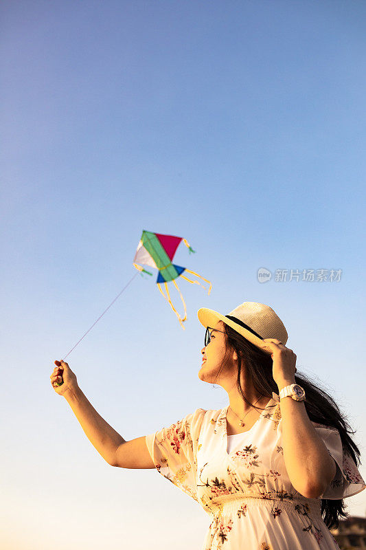 亚洲女人在海滩上放风筝