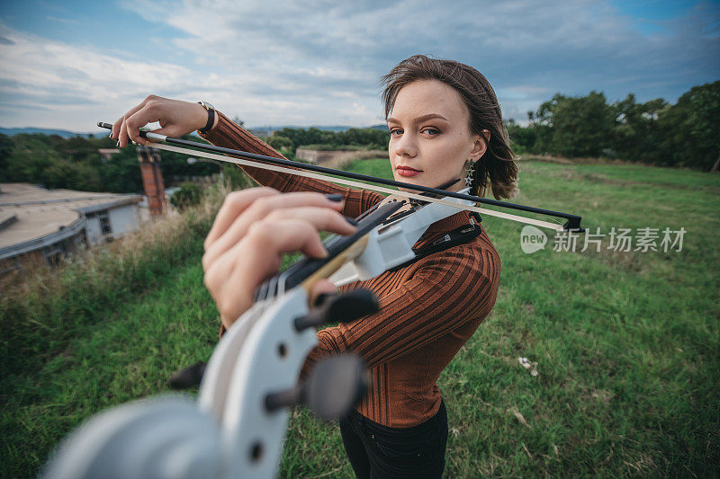 年轻女子在户外拉小提琴