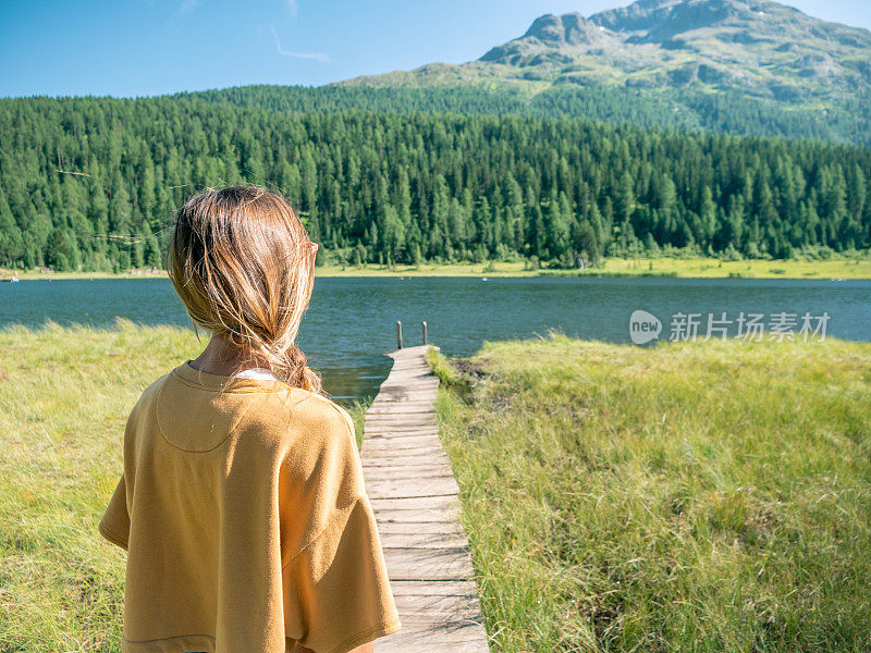 年轻女子在湖边码头休息