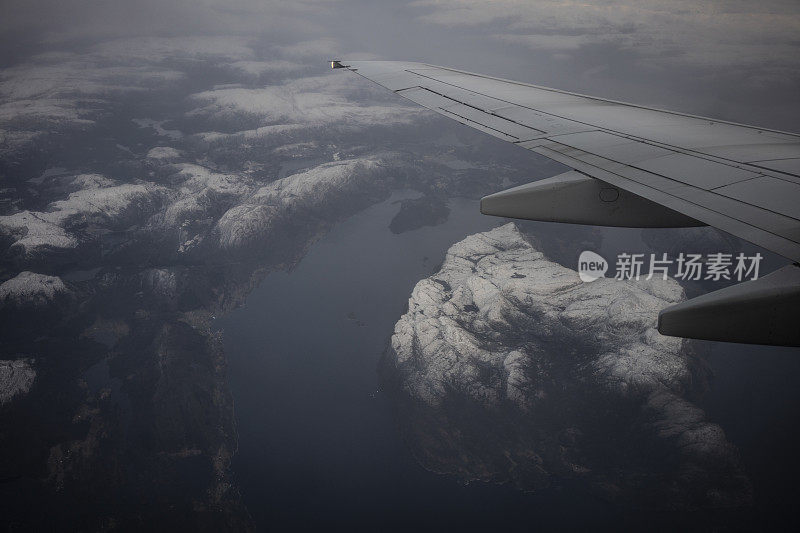 乘客从飞机上俯瞰挪威的峡湾，山上覆盖着积雪