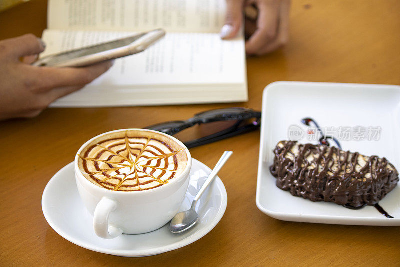 情侣们在咖啡馆里一边看书，一边喝咖啡。