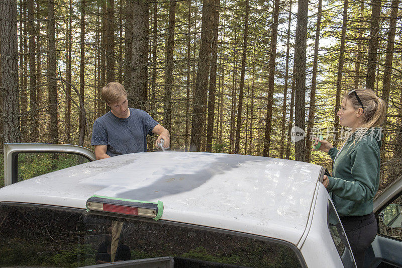 朋友们在森林里给卡车刷车顶