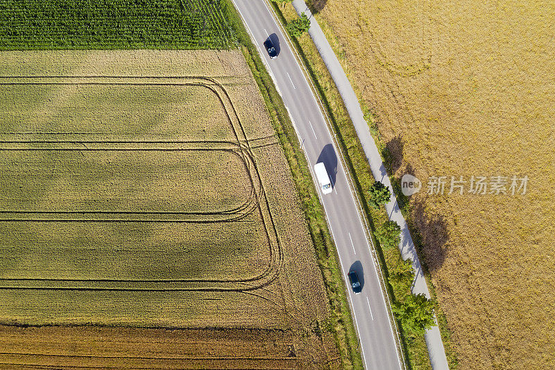 三辆车在田野之间的道路上，鸟瞰图