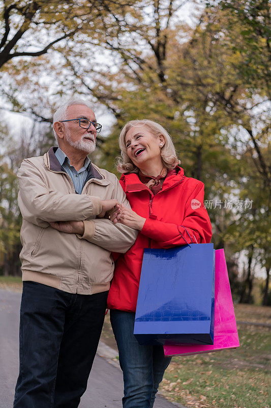 一对老年情侣正在公园散步，享受一个秋天的午后。