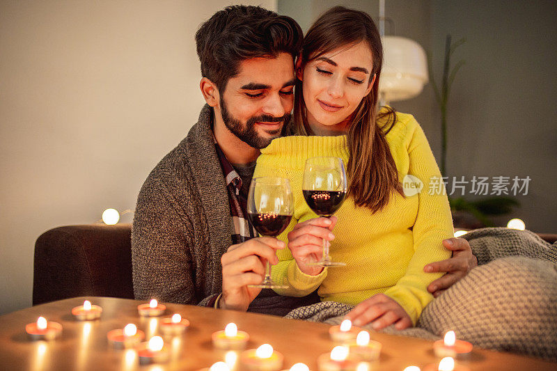 相爱的年轻夫妇在家里喝酒庆祝情人节