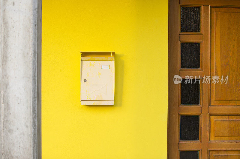 黄色门面上有信箱和一根柱子