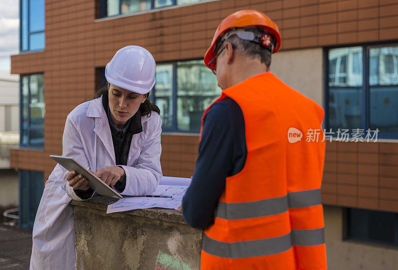 男女工程师在现场讨论技术问题