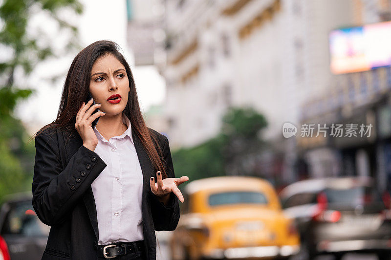 女商人在街上用手机聊天。