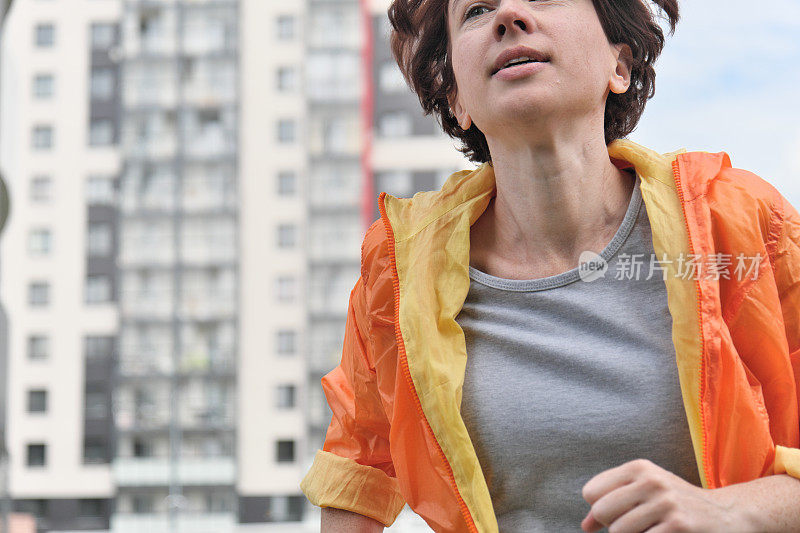 成熟的女人在城市邻里奔跑