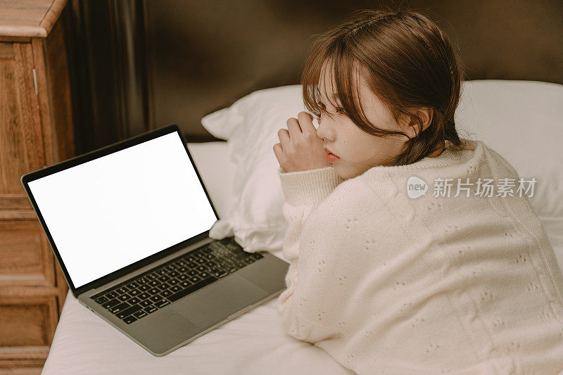亚洲女孩躺在床上摆弄电脑