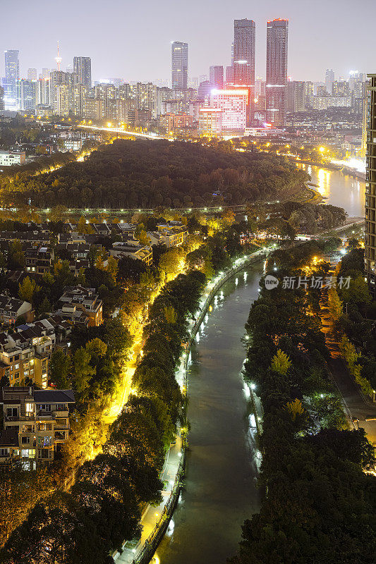 繁华密集的城市建筑、河流和树木拍摄在成都的夜晚