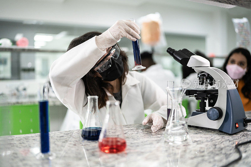 十几岁的女孩在学校或大学的实验室里做实验
